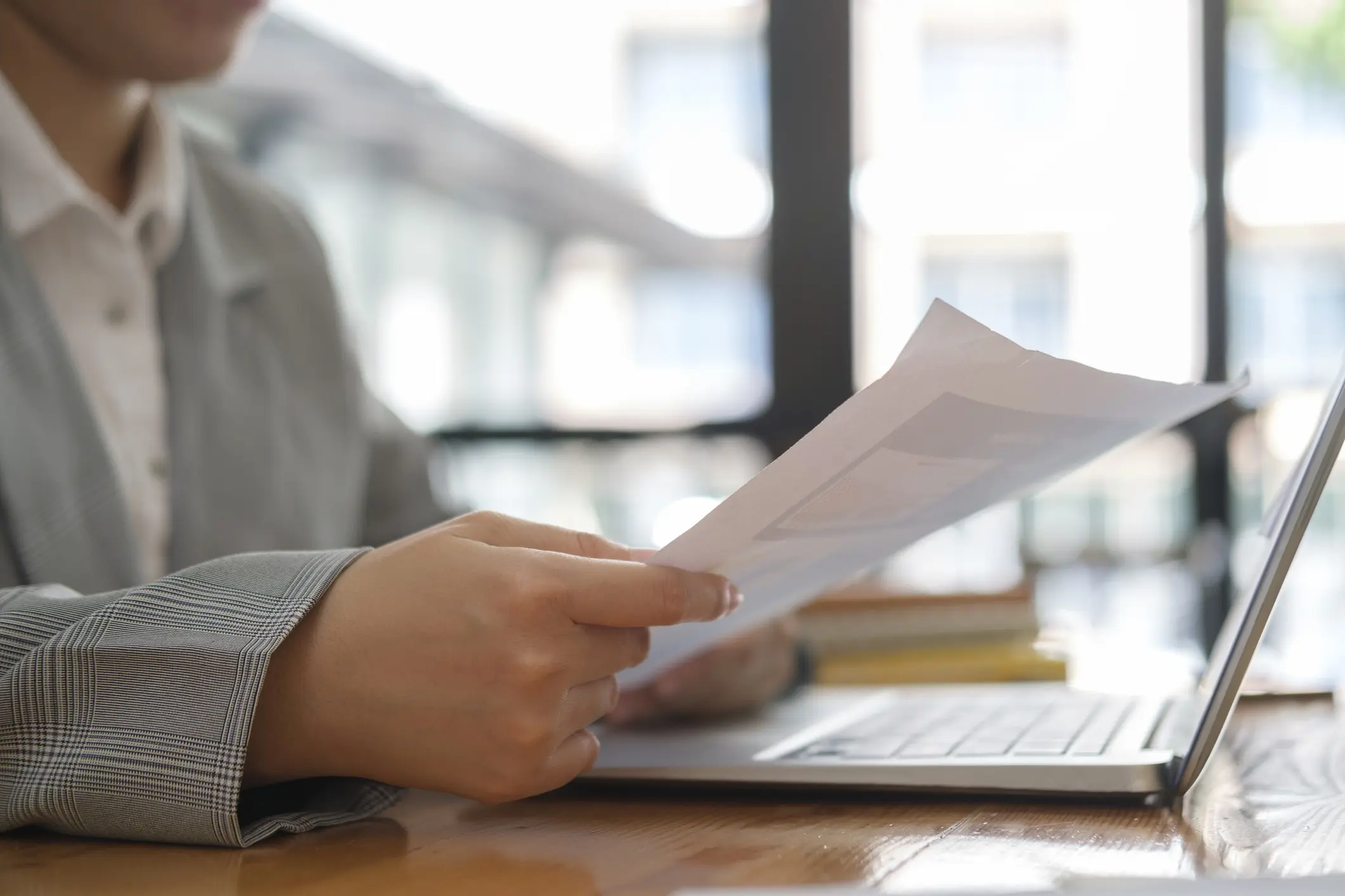 Person reviewing documents at a laptop