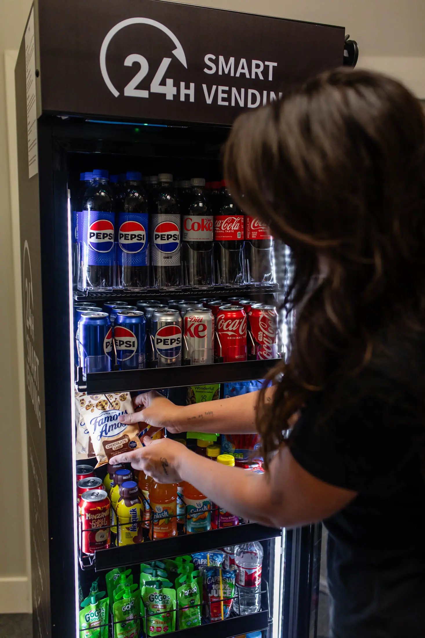 Person selecting soda from 24h vending machine